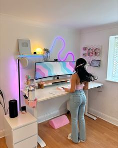 a woman standing in front of a computer desk