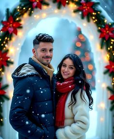 a man and woman standing in front of a christmas wreath