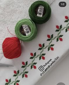 two balls of yarn sitting on top of a white towel next to a pair of scissors