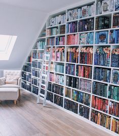 there is a book shelf full of books on the wall next to a chair and window