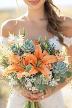 a bride holding a bouquet of orange flowers and succulents in her hands