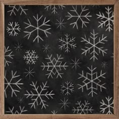 snowflakes are drawn on a blackboard in a wooden frame