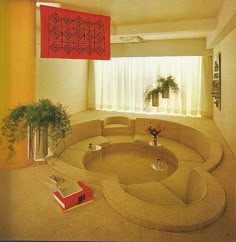 a living room filled with furniture next to a window and potted plant on the floor