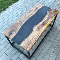 a wooden table sitting on top of a brick sidewalk