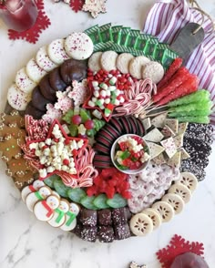 a platter filled with lots of different types of cookies and candies on top of a table