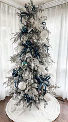 a white christmas tree with blue and silver ornaments