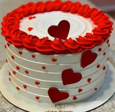 a white cake with red hearts on it