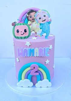 a pink cake with two little kids on top