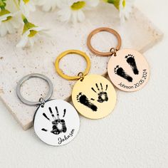 three personalized key chains with handprints on them