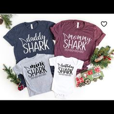 three shirts with the words mommy shark, daddy shark and mommy shark on them next to christmas decorations