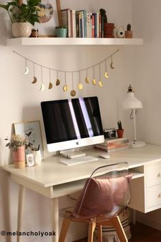 a white desk with a computer on top of it next to a shelf filled with books