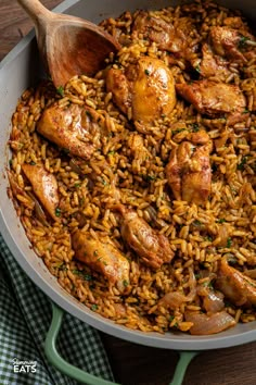 chicken and rice in a skillet with a wooden spoon on the side, ready to be eaten