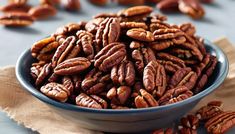 a blue bowl filled with pecans on top of a table