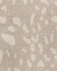 an animal print fabric with white spots on the top and bottom, in neutral tones