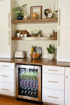 an open refrigerator in a kitchen next to white cabinets