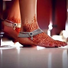 the feet and ankles of a woman with henna tattoos