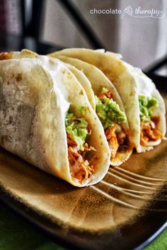 three tortillas with guacamole and other toppings on a purple background