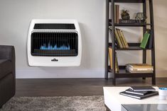 a living room with a heater on the wall next to a couch and bookcase