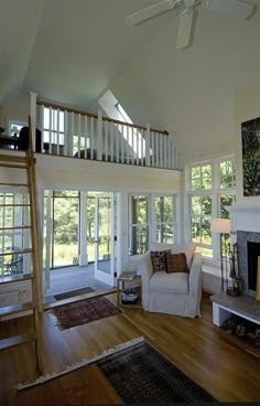 a living room filled with furniture and a fire place in front of a staircase leading up to a second story