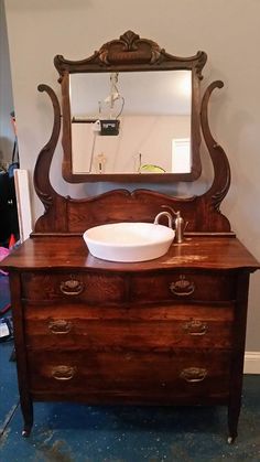 an old dresser with a sink and mirror