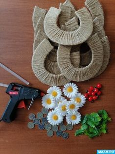 some flowers are sitting on a table next to scissors and other crafting supplies that include yarn