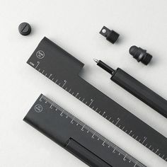 some tools are laying out on a white surface with one measuring ruler and two screws