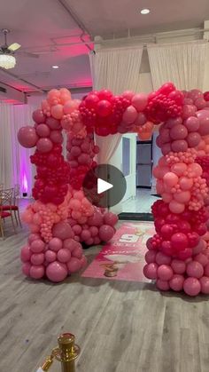 a room decorated with pink and red balloons