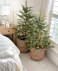 two baskets filled with christmas trees sitting on top of a bed