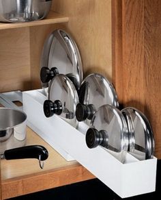 pots and pans are stored in the cabinet drawer for storage or to be put on