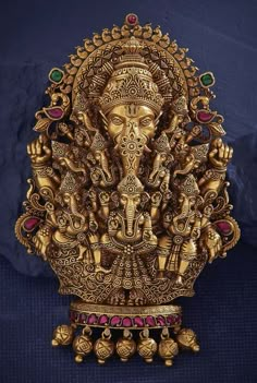 an intricately decorated ganesha statue on display in front of a blue background