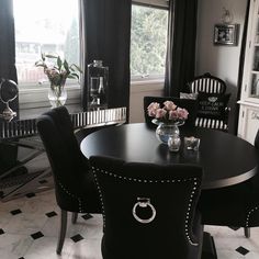 a black and white dining room table with some flowers on it's centerpiece