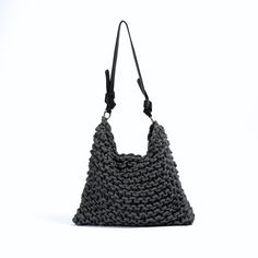 a crocheted bag is shown on a white background with black handles and straps