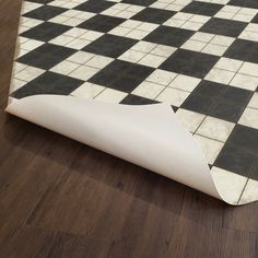 a black and white checkered floor with a roll of paper on the ground next to it