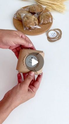 a person holding a cookie in front of some cookies on a table with other items