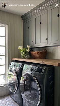 a washer and dryer in a small room with cabinets on either side of the window