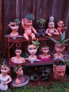 a shelf filled with potted plants and dolls on top of it's sides