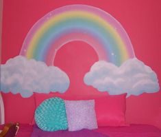 a bedroom with pink walls and a rainbow painted on the wall above the headboard