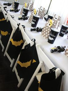 a long table topped with black and yellow batman bags