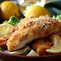 a close up of a plate of food with lemons and other foods on the side