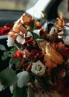 a bouquet of flowers sitting on the dashboard of a car