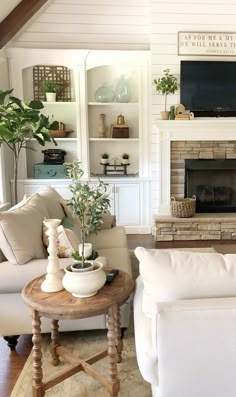 a living room filled with furniture and a flat screen tv mounted on the wall above a fire place