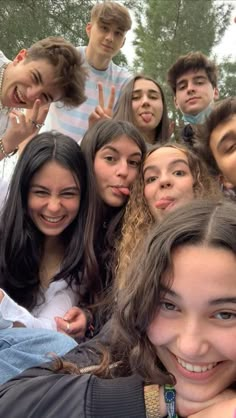 a group of young people standing next to each other posing for the camera with their fingers in the air