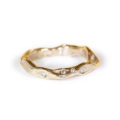 a gold ring with three diamonds on the inside and outside, set against a white background