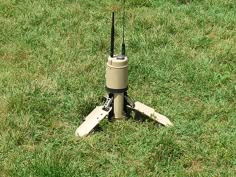 a small radio tower sitting on top of a lush green grass covered field next to a pair of skis