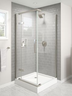 a bathroom with a walk in shower next to a white tiled wall and flooring