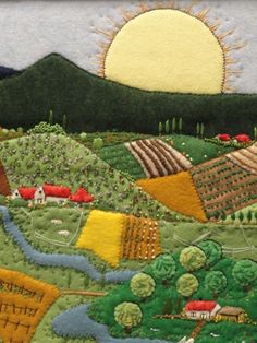 an embroidered landscape is shown with mountains and fields