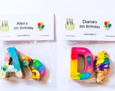 two plastic letters with birthday candles on them are shown in the same package as each other