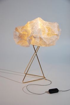 a lamp that is sitting on top of a metal stand with a chain attached to it