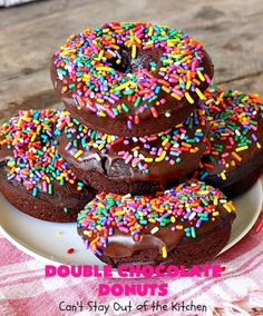 there are chocolate donuts with sprinkles on the plate