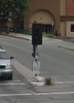 a car is driving down the street in front of a traffic light that has been knocked over